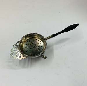 Silver plated tea strainer on a stand