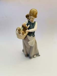 Lladro girl holding a basket of puppies