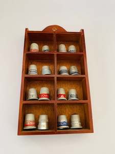 Set of 16 metal Advertising thimbles in a wooden display case
