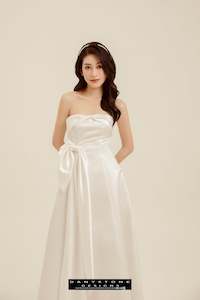 Elegant Strapless Wedding Dress with Bow Accent and Flowing Skirt