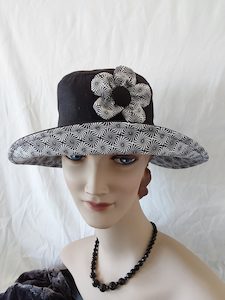 Products: R250: Black linen/cotton hat with geometric design trim and 5 petal flower feature. Hokianga Hats