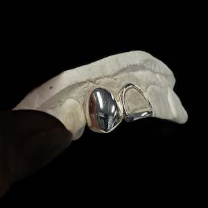 custom made grillz: Two teeth in Sterling Silver, one fully capped one framed