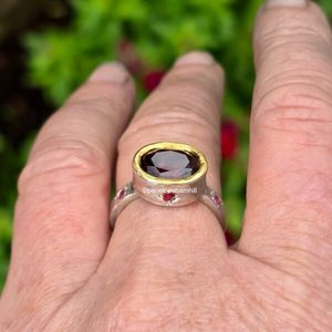 Products: Empress ring. 10x8mm Tanzanian garnet, rubies, silver and 24ct gold. Size P1/2. Can be resized. - Penelope Barnhill Jewellery