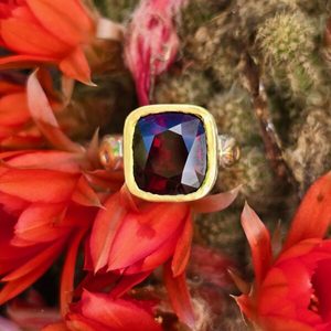 Products: Enchanted garden garnet cushion 12.5x10.5mm, 4.6ct, sapphires and ruby. Silver and 24ct gold. - Penelope Barnhill Jewellery