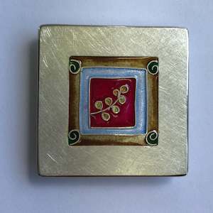 Brooch: Brooch, small leaf on red with koru's