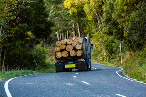 A logging truck driving down a twisty road, Hawke's Bay, New Zealand - SCP Stock