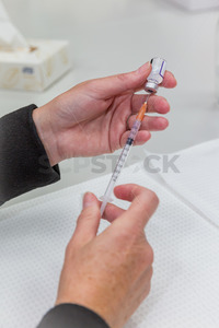 Products: Doctor / Nurse drawing a vaccination syringe - SCP Stock