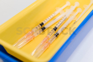 Medical syringes ready to use in a yellow plastic tray - SCP Stock