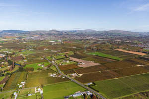 Aerial view looking over rural land towards Havelock North, with the three peaks&hellip;